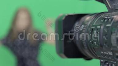 一个女孩正在绿色背景下录制节目